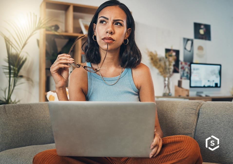 Proprietário em condomínio com expressão de dúvida, pensativo de óculos trabalhando no notebook em ambiente de home office com plantas. Proprietário em condomínio com expressão de dúvida, pensativo de óculos trabalhando no notebook em ambiente de home office com plantas.