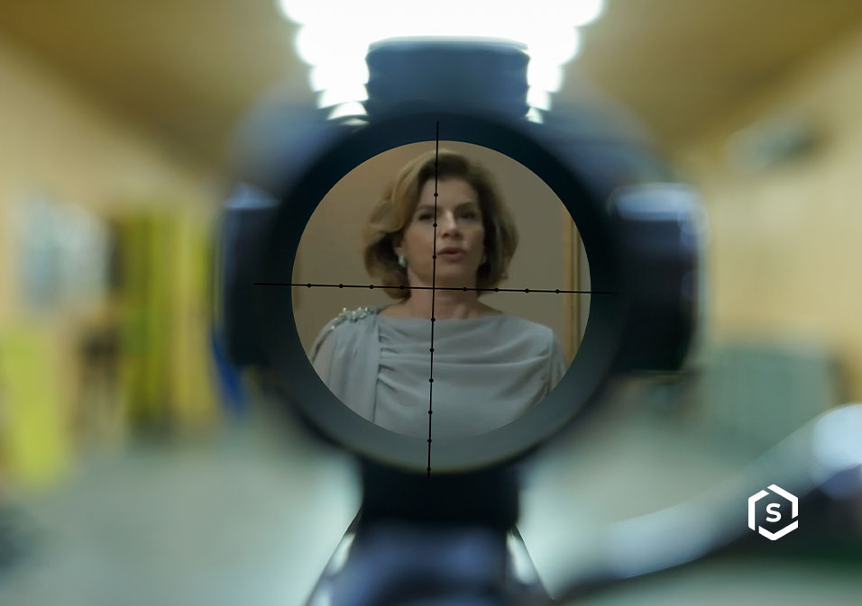 Imagem da personagem Odete Roitman observada através de uma mira de arma de fogo, na cena de novela Vale Tudo, focada em tensão e suspense Imagem da personagem Odete Roitman observada através de uma mira de arma de fogo, na cena de novela Vale Tudo, focada em tensão e suspense