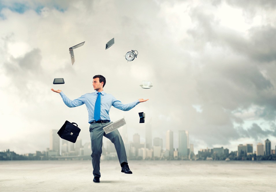 Síndico equilibrando objetos do escritório, como laptop, relógio e celular, em um cenário urbano com céu nublado, simbolizando gestão de tempo