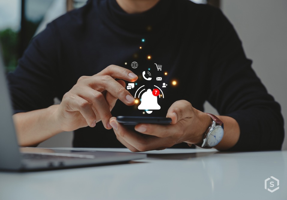 Pessoa usando smartphone com notificações de mensagens, chamadas, compras online e redes sociais, ilustrando gerenciamento de comunicação digital.