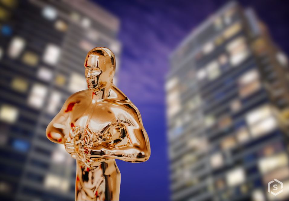 Estatueta do Oscar dourada em frente a edifícios modernos à noite, simbolizando sucesso e reconhecimento na indústria cinematográfica.