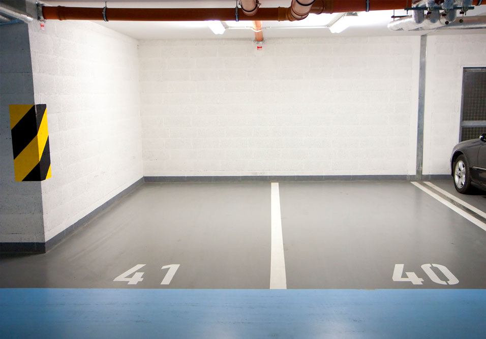 Vaga de garagem interna numerada 47 e 40 em estacionamento subterrâneo, com piso cinza, faixa de demarcação e parede clara ao fundo