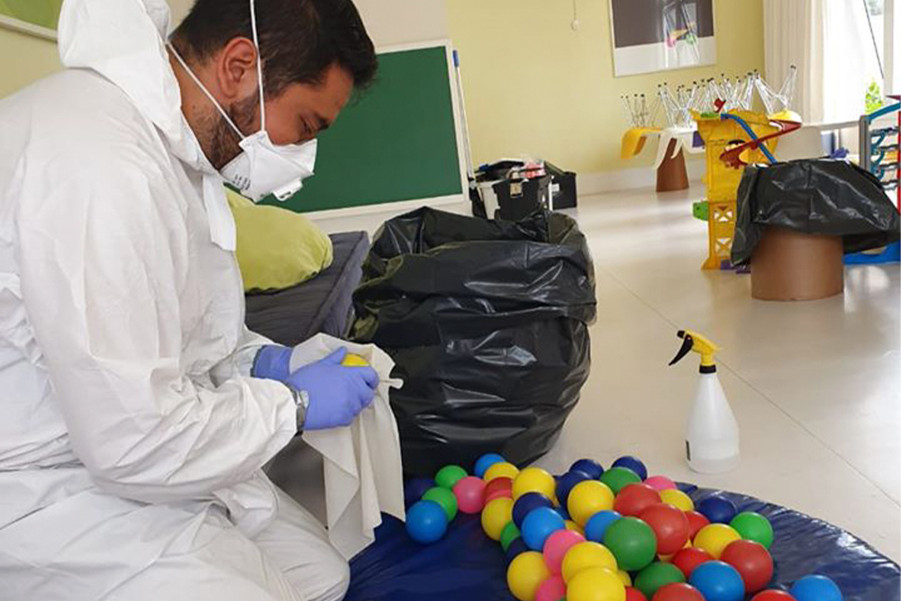 Homem desinfetando brinquedoteca Homem desinfetando brinquedoteca